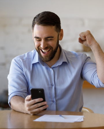 une personne tenant un téléphone et levant le poing